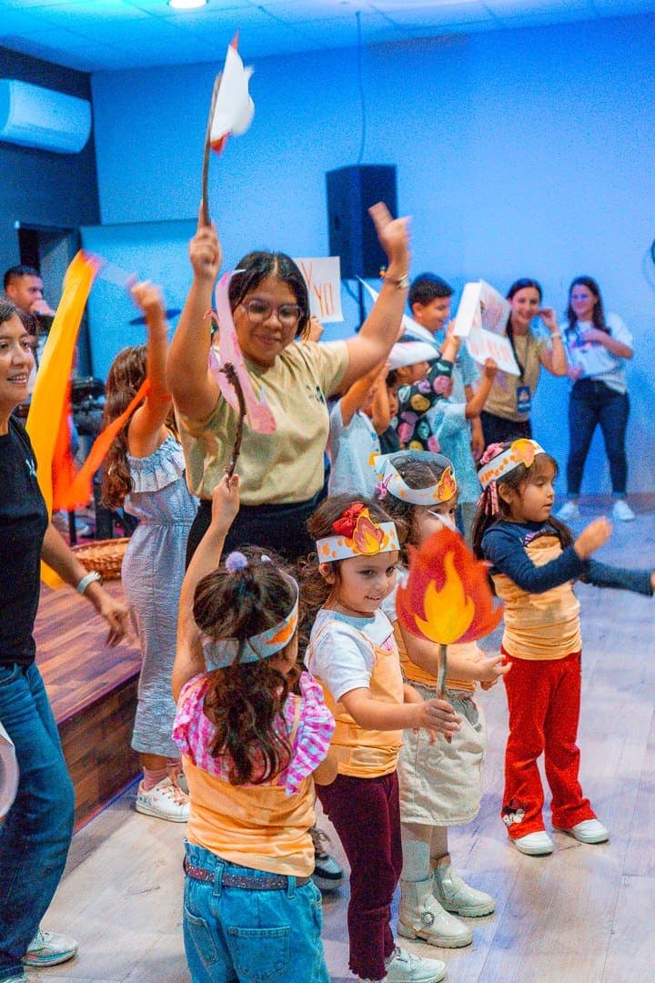 Los niños del ministerio infantil desfilando con antorchas de papel y cintas de colores
