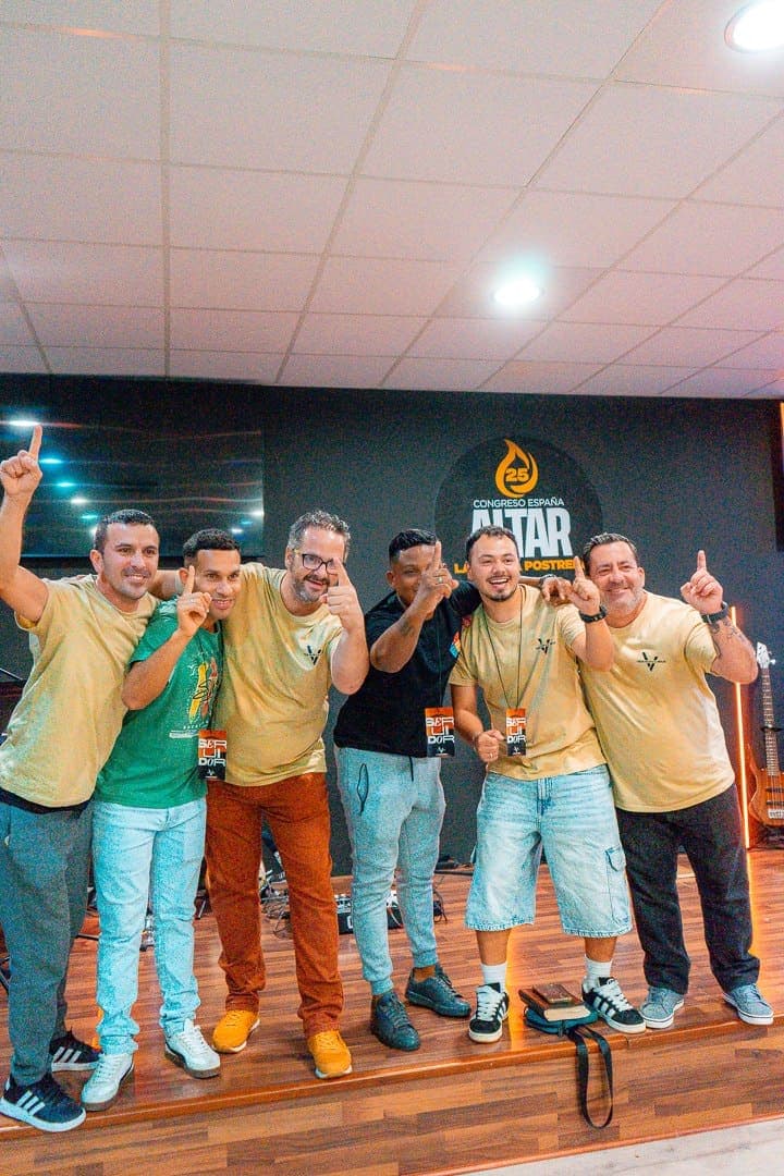 Seis voluntarios del equipo de servidores posando juntos sobre la tarima