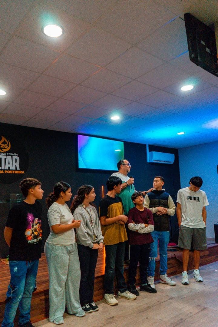 Los jóvenes de la iglesia en fila junto a la tarima mientras se ora por ellos